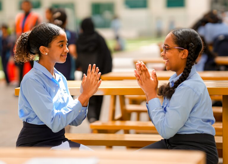 two students playing with hands