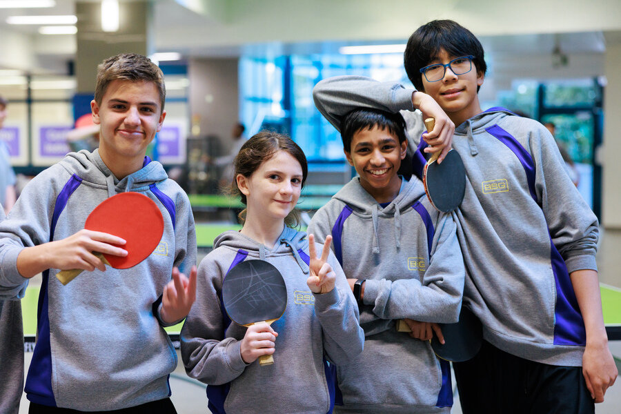 four students with table tennis rackets